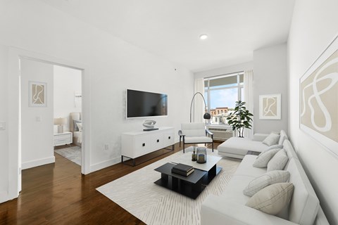 A living room with a white couch and a black coffee table.